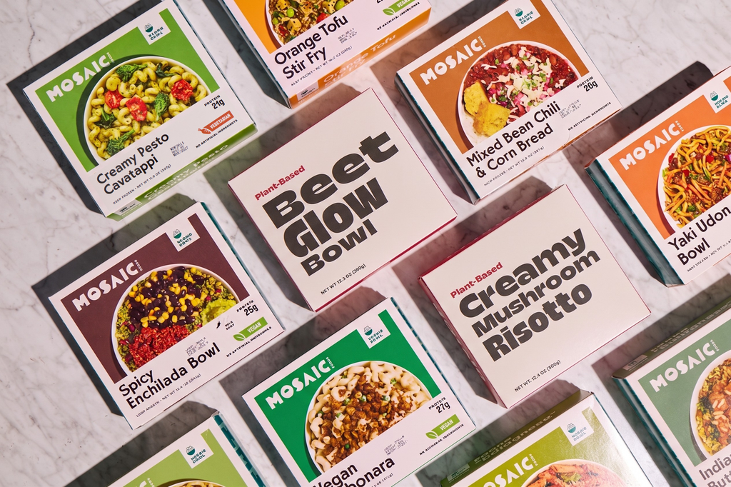 Mosaic Foods and Splendid Spoon meal boxes laying on a gray table