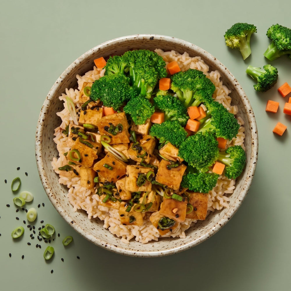 Tofu Teriyaki served over brown rice with steamed broccoli florets, diced carrots, and scallions
