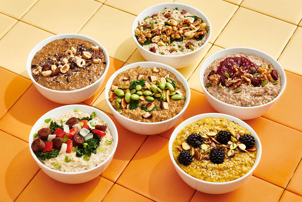 Six oat bowls with various toppings on a yellow and orange checkered tablecloth.